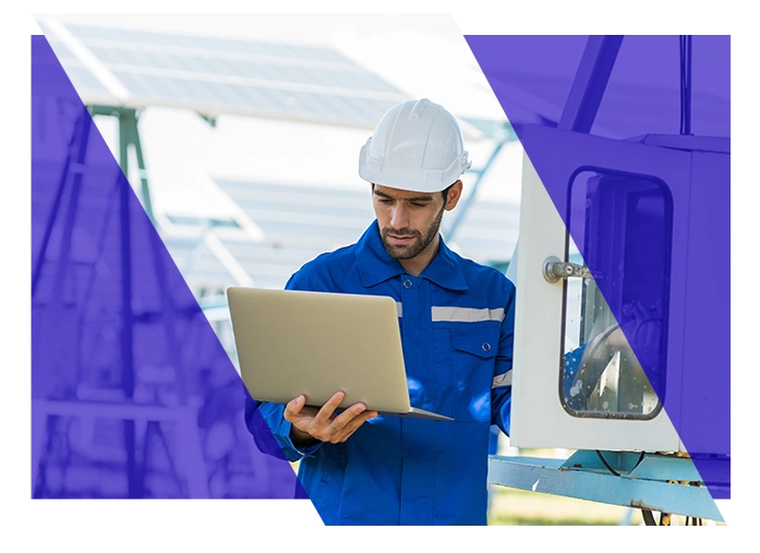 Electrical contractor using a laptop beside field equipment