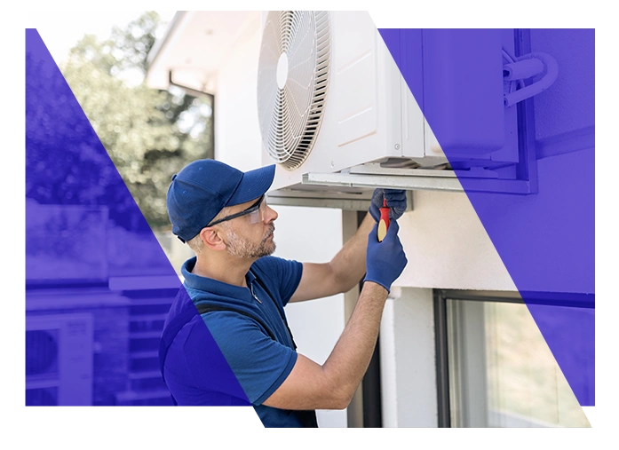 HVAC technician servicing an outdoor air conditioning unit