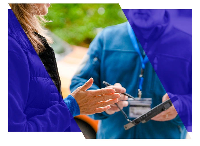HVAC technician discussing a mobile device with a coworker at a job site