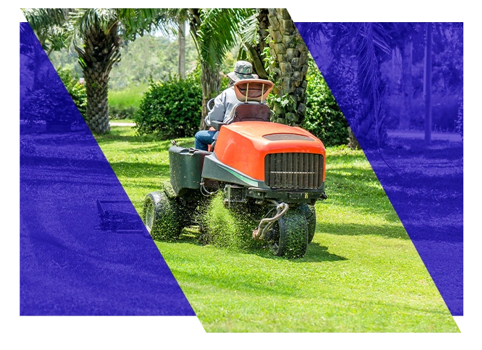 Landscaping worker operating a lawn mower in a residential yard