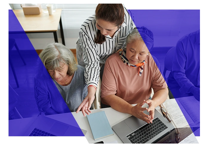 Team members reviewing documents and information on a laptop together