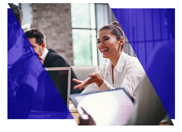 Business professionals discussing work around computers in an office